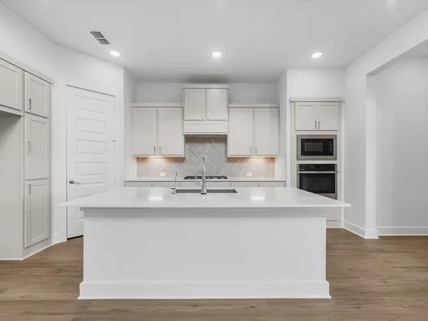 a kitchen with kitchen island white cabinets and stainless steel appliances