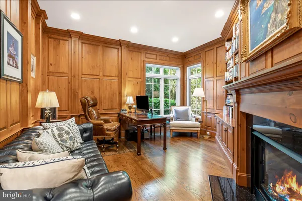 a living room with furniture a fireplace and large windows