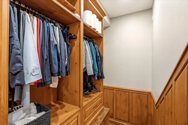a view of walk in closet with clothes and shoes