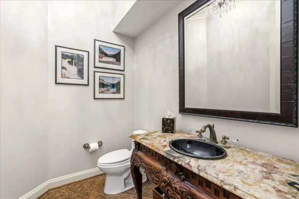 a bathroom with a granite countertop toilet sink and mirror
