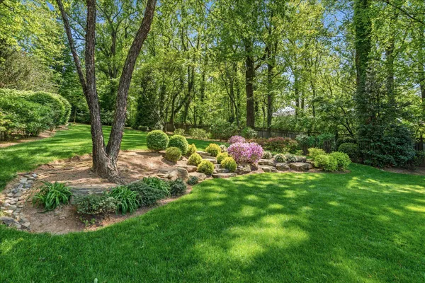 a backyard of a house with lots of green space and fountain