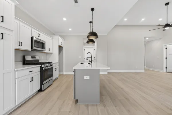 a kitchen with stainless steel appliances a sink a stove oven a counter space and cabinets