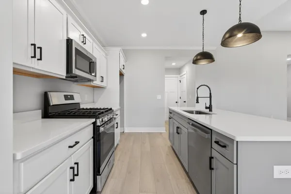 a kitchen with stainless steel appliances granite countertop a sink a stove and a wooden floors