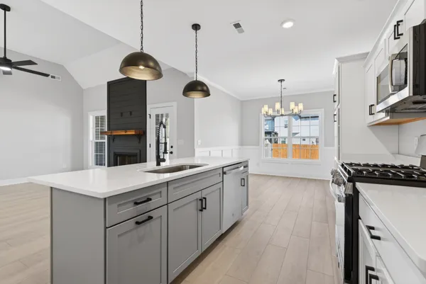 a kitchen with a sink a stove and cabinets