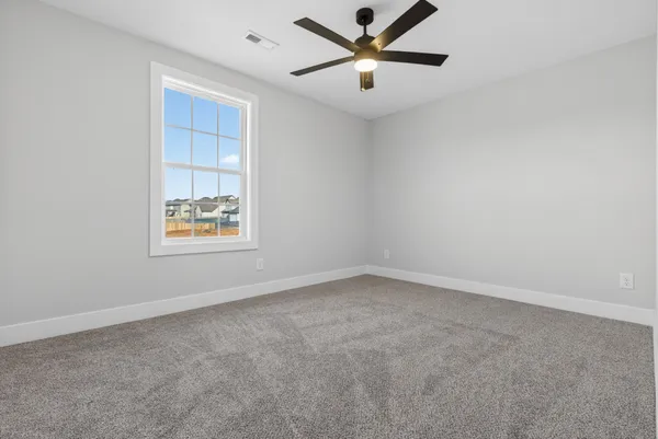 an empty room with windows and ceiling fan