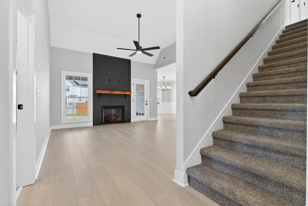 a view of a livingroom with a fireplace and a ceiling fan
