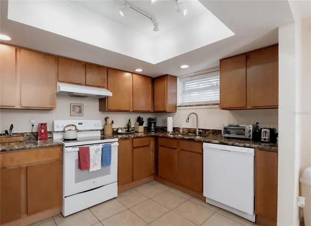 a kitchen with stainless steel appliances granite countertop a sink a stove and cabinets