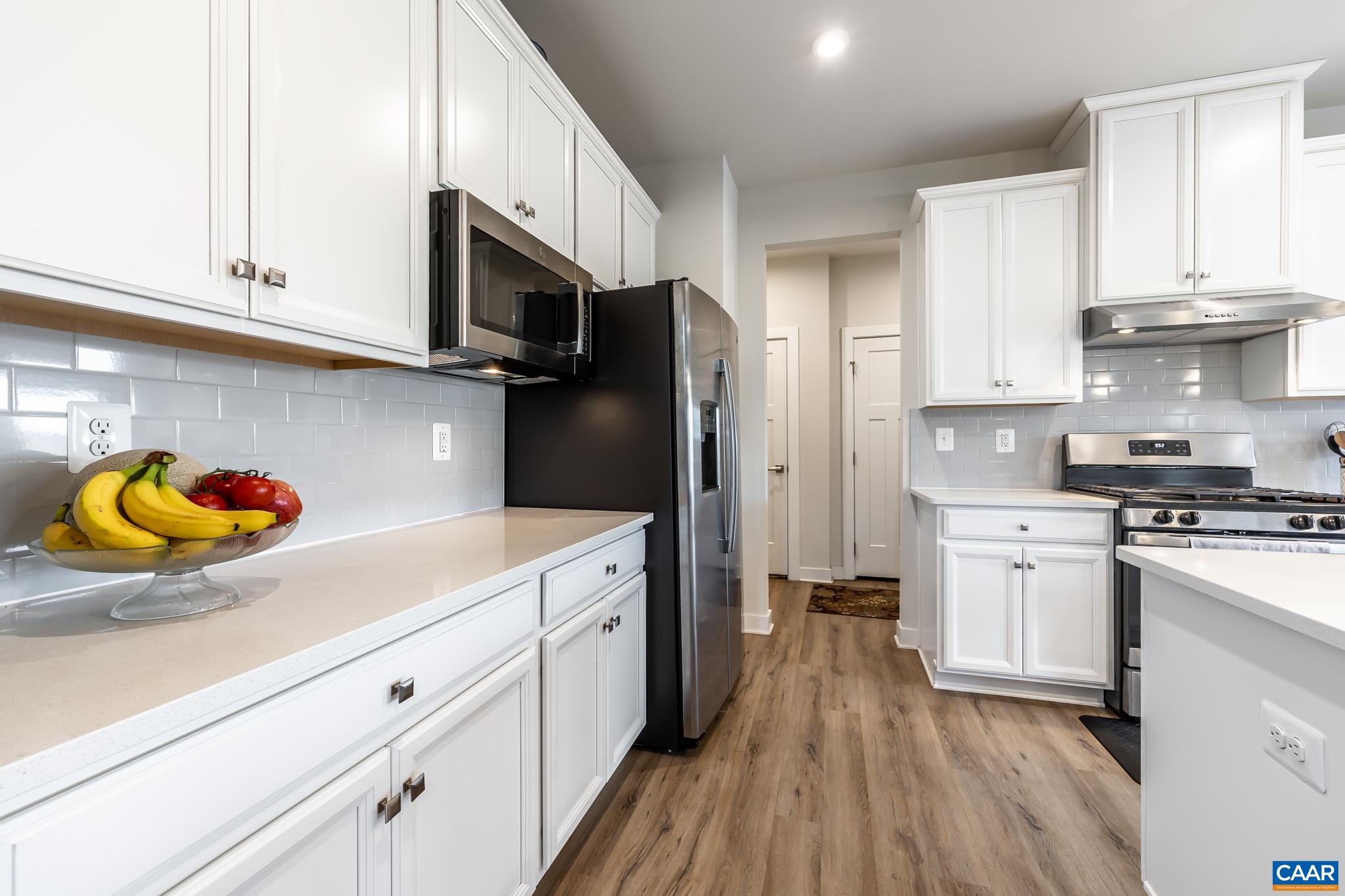 4585 Sunset Drive Charlottesville, VA 22911 - Photo 34 of 70 a kitchen with stainless steel appliances granite countertop a refrigerator a stove and white cabinets with wooden floors