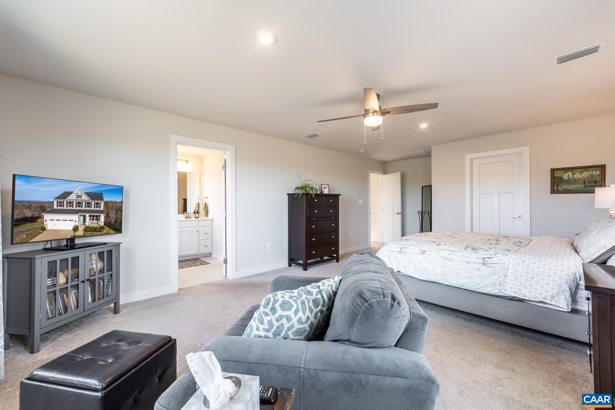 4585 Sunset Drive Charlottesville, VA 22911 - Photo 40 of 70 a spacious bedroom with a bed a couch and a chandelier