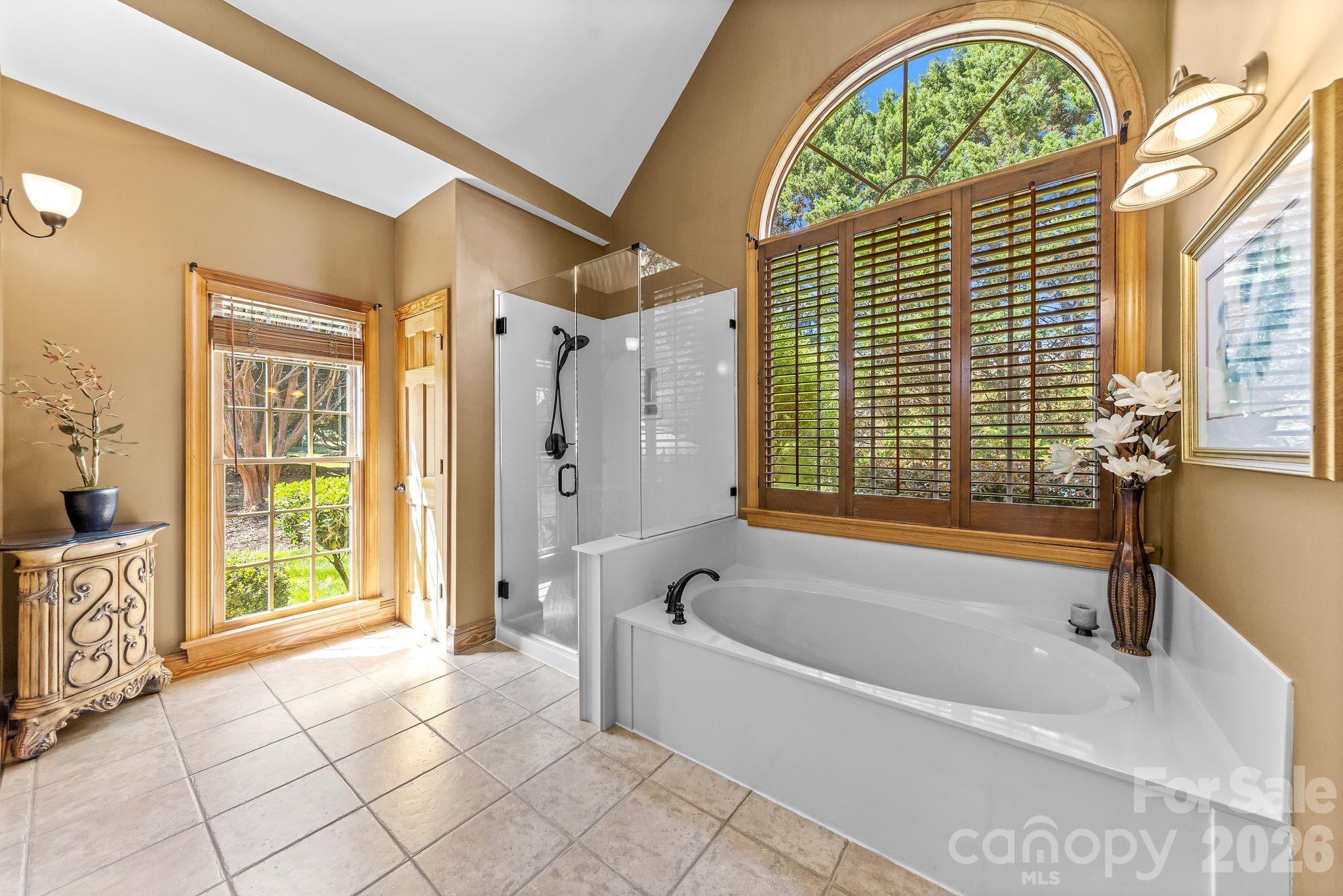 3530 Cardiff Lane Matthews, NC 28104 - Photo 24 of 39 a bathroom with a tub a window and a shower