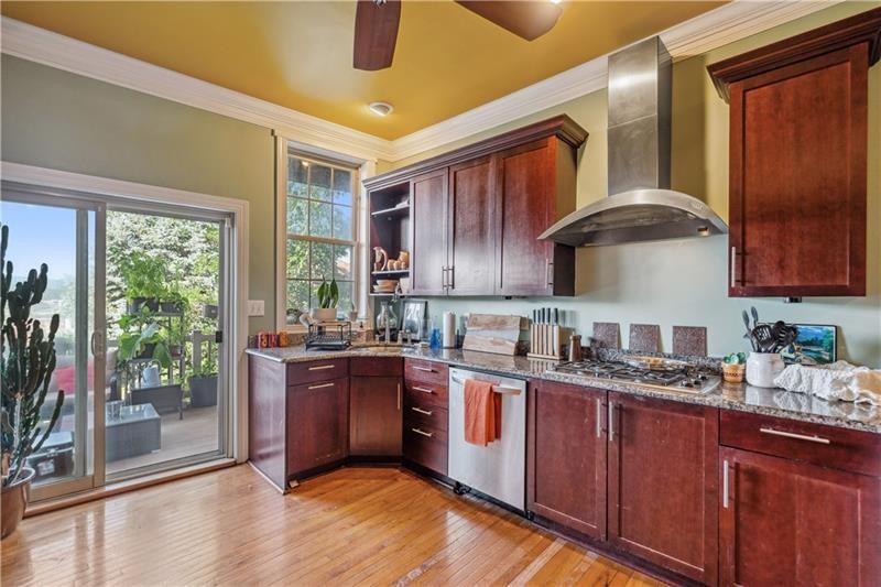 167 Pius Street Pittsburgh, PA 15203 - Photo 12 of 49 a kitchen with stainless steel appliances granite countertop a sink a stove and a wooden floors