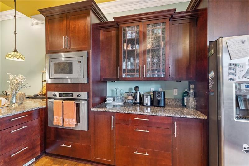 167 Pius Street Pittsburgh, PA 15203 - Photo 13 of 49 a kitchen with stainless steel appliances granite countertop a refrigerator and wooden cabinets