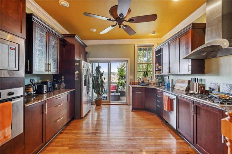 167 Pius Street Pittsburgh, PA 15203 - Photo 10 of 49 a kitchen with stainless steel appliances wooden floors stove and cabinets