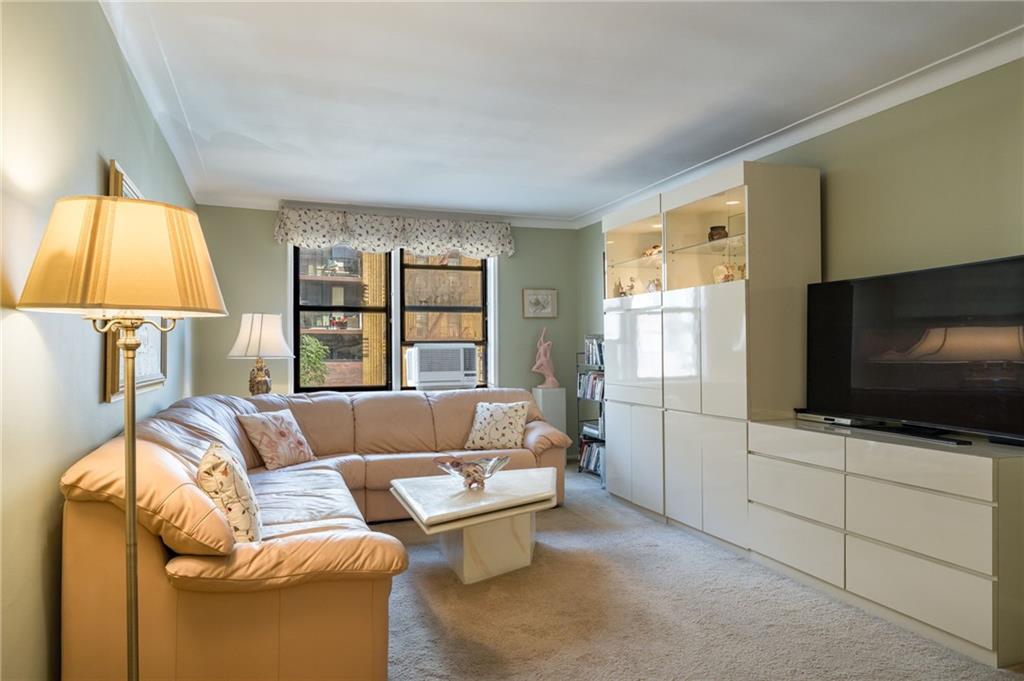 3060 Ocean Avenue, Unit 2L Brooklyn, NY 11235 - Photo 2 of 13 a living room with a couch and a flat screen tv