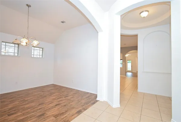 a view of empty room with window and wooden floor