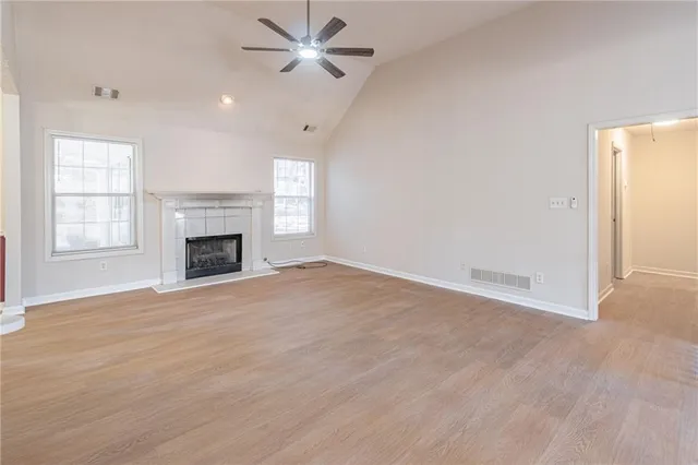 an empty room with windows and fireplace