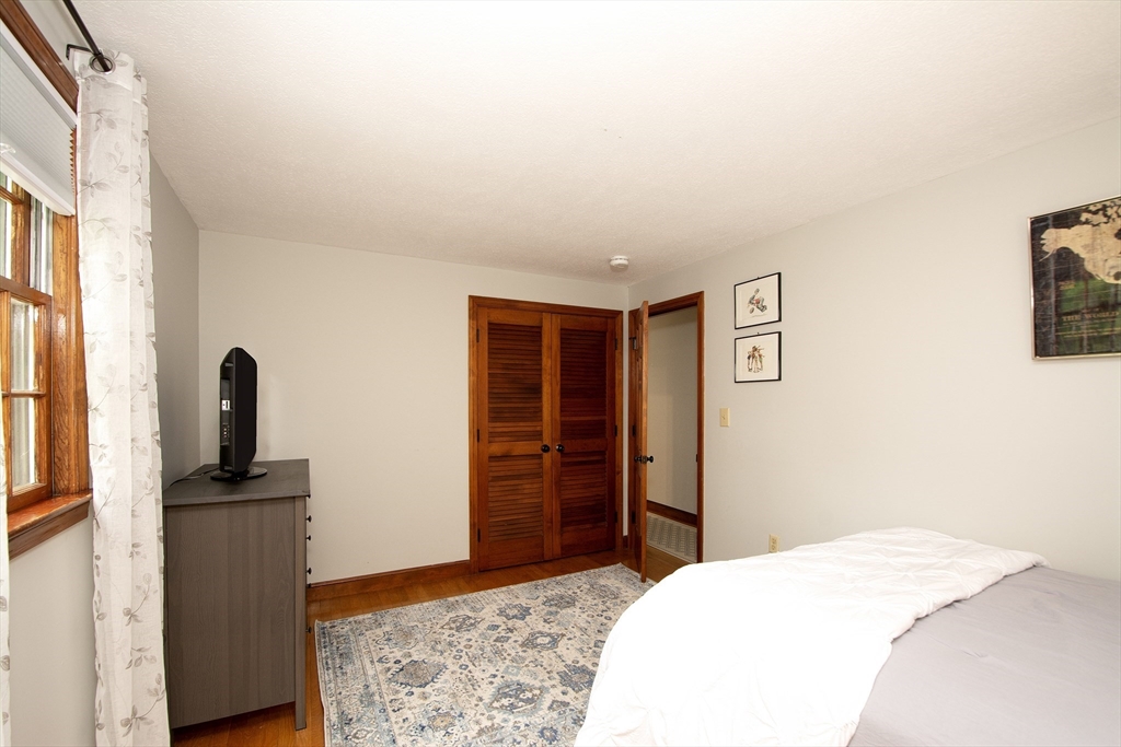 26 Old Coach Road Cohasset, MA 02025 - Photo 22 of 33 a bedroom with a bed and wooden floor