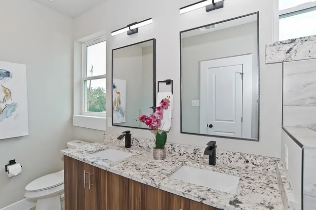 a bathroom with a granite countertop sink and a mirror