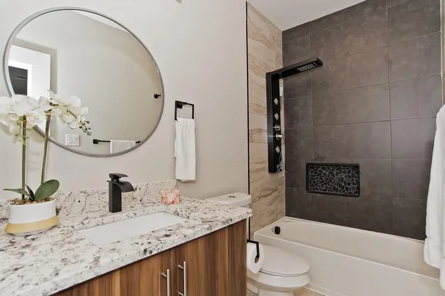 a bathroom with a granite countertop sink a toilet and a mirror