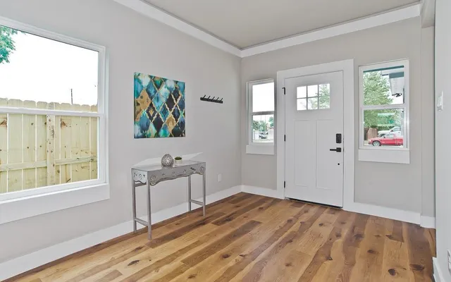 a view of a hallway with wooden floor and windows