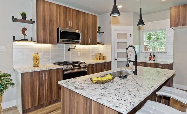 a kitchen with a stove a sink a microwave a dining table and chairs