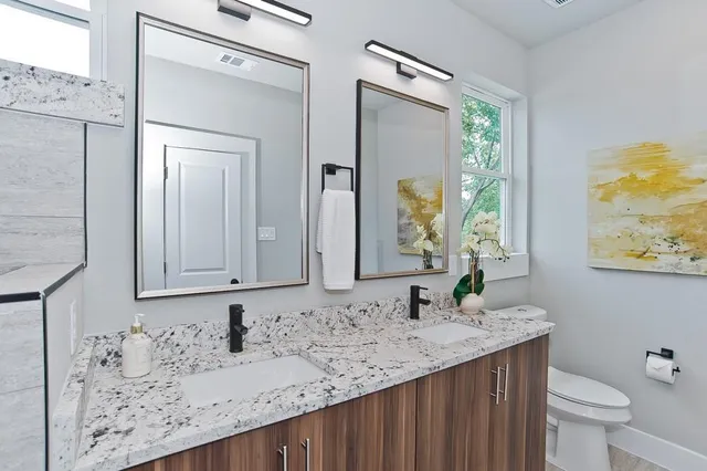 a bathroom with a granite countertop sink and a mirror