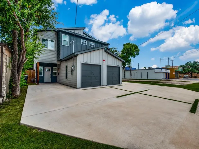 a view of a house with a backyard and a garage