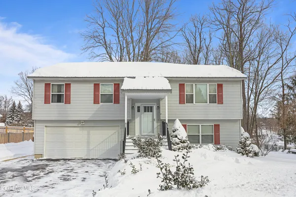 a front view of a house with a yard covered in snow
