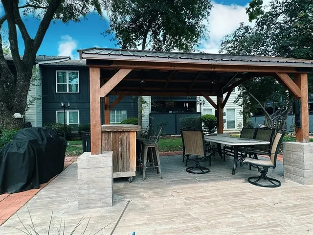 a view of patio with table and chairs and potted plants