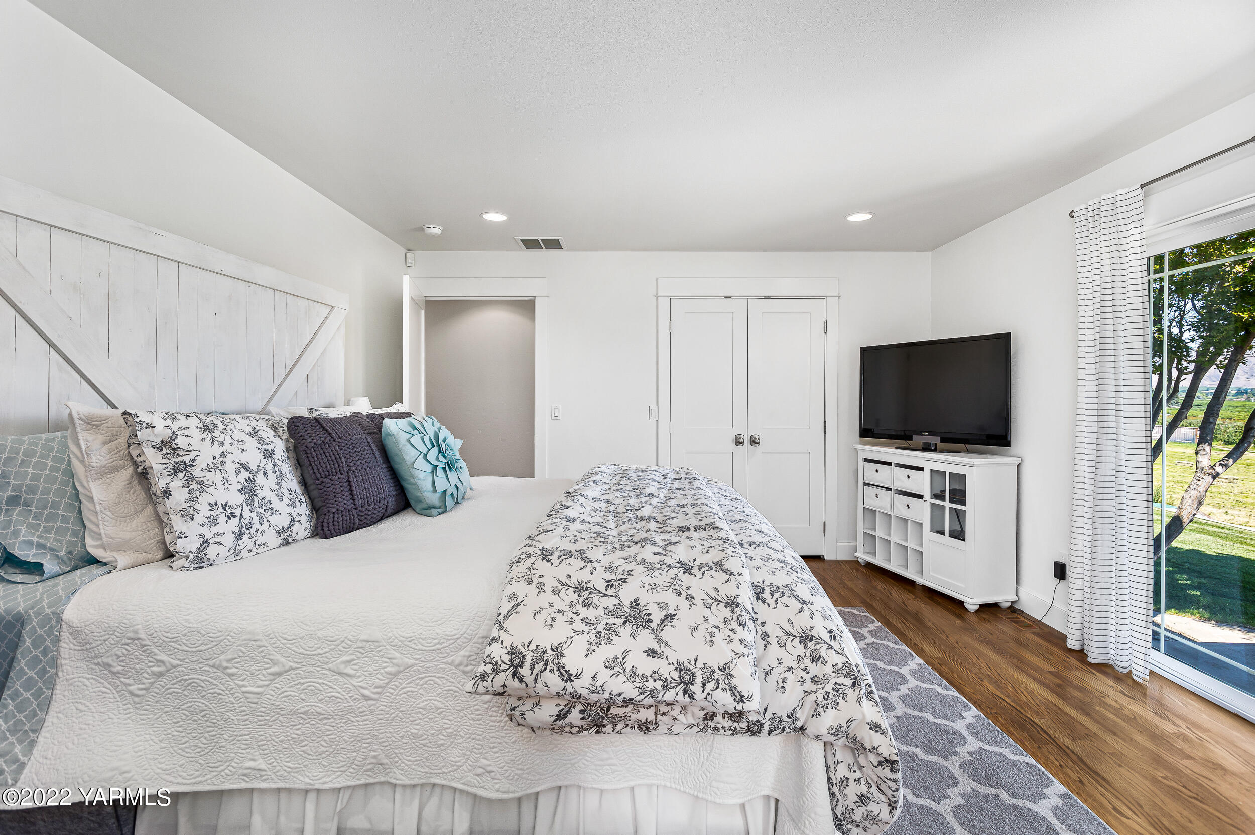 190 Nash Road Tieton, WA 98947 - Photo 23 of 38 a spacious bedroom with a bed and a flat screen tv