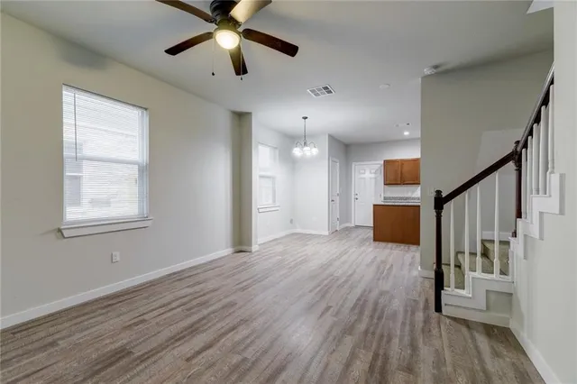 a view of empty room with wooden floor and window