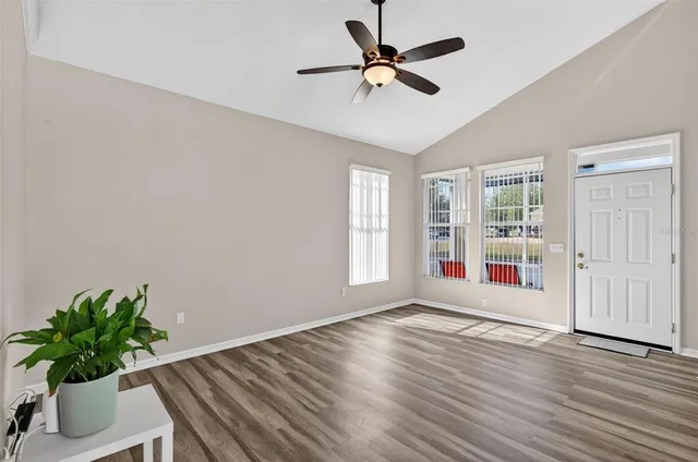 a view of an empty room with a window and wooden floor