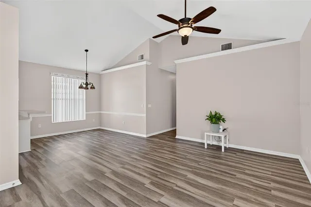 a view of an empty room with wooden floor a ceiling fan and closet