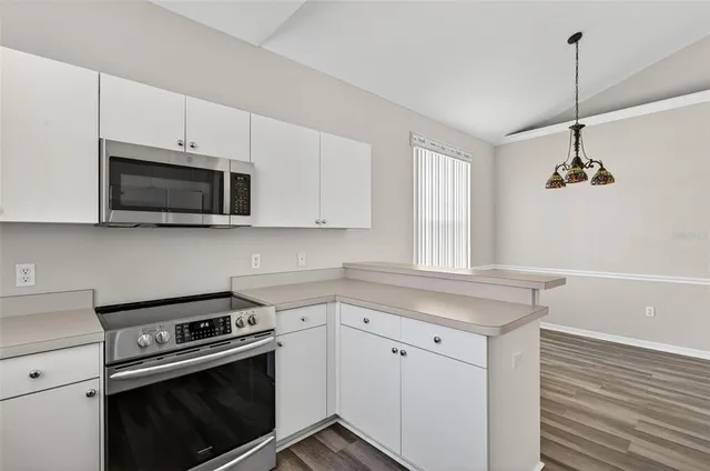 a kitchen with stainless steel appliances a sink a stove and microwave