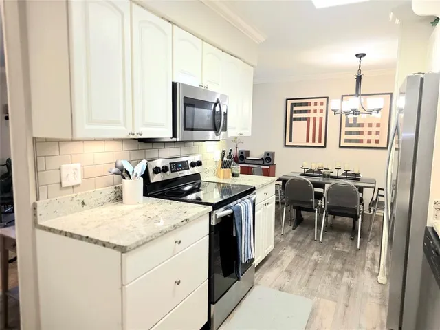 a kitchen with a sink stove and white cabinets
