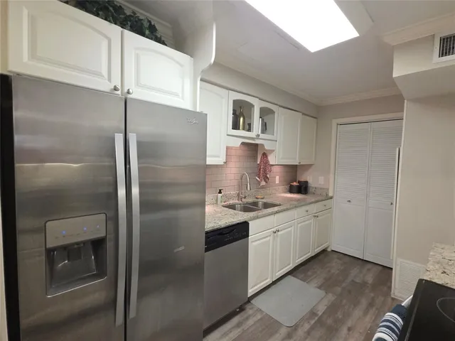 a kitchen with stainless steel appliances granite countertop a refrigerator and a stove