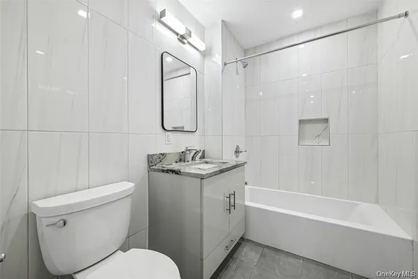 a bathroom with a granite countertop sink a toilet and shower