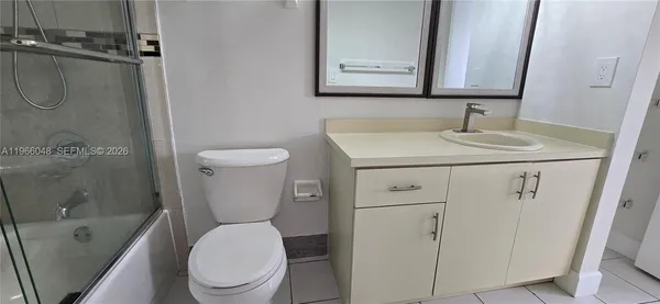 a bathroom with a granite countertop toilet sink and mirror