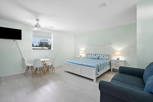 a spacious bedroom with a bed a couch and a flat screen tv