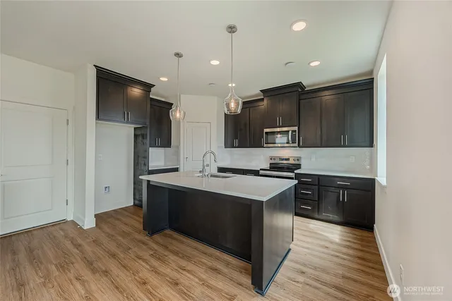 a kitchen with stainless steel appliances granite countertop a stove a sink and a refrigerator
