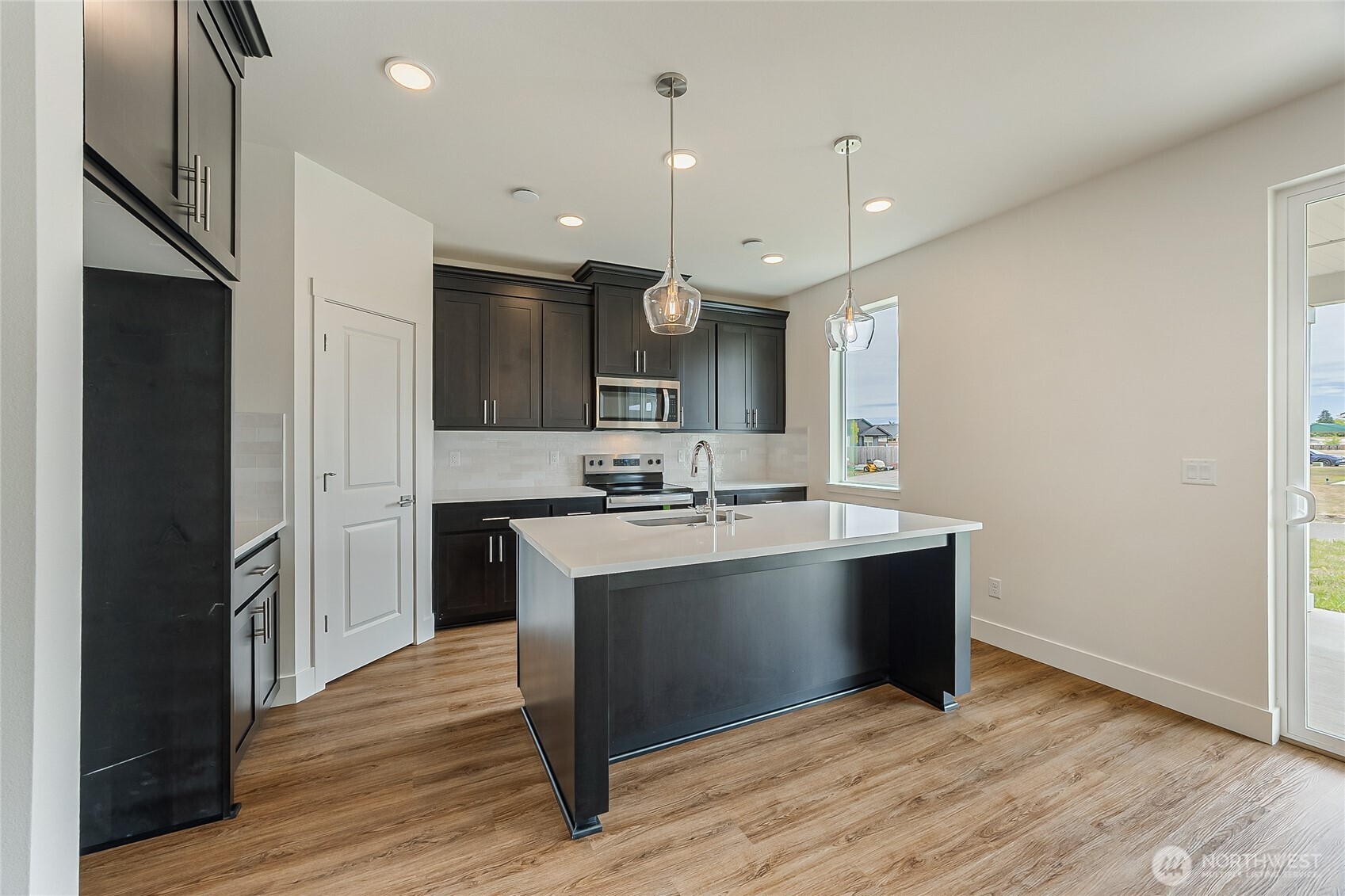 404 Pagget Avenue Winlock, WA 98596 - Photo 12 of 40 a large kitchen with stainless steel appliances granite countertop a sink a stove and a wooden floors