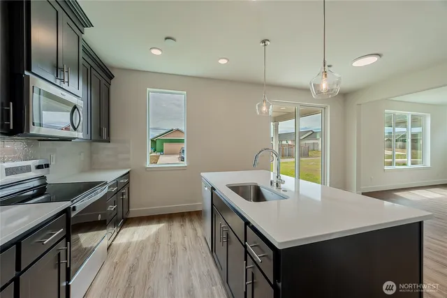 a kitchen with a stove a sink and a refrigerator