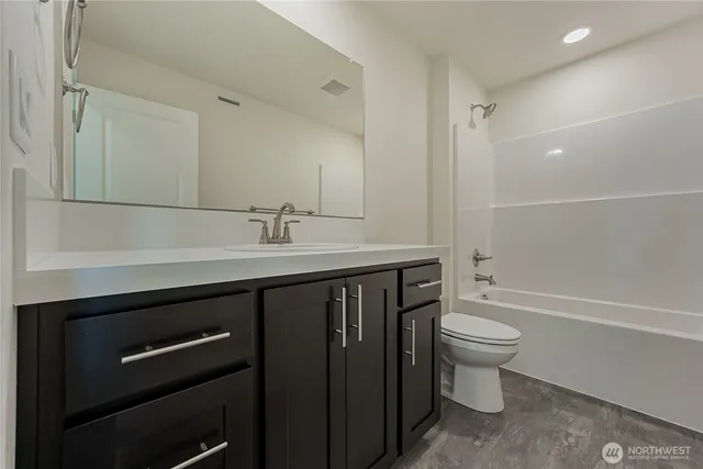 a bathroom with a sink a toilet a mirror and bathtub