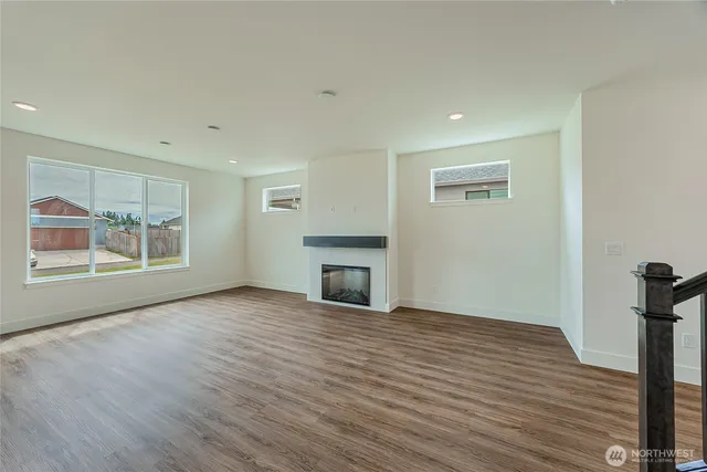 a view of empty room with wooden floor and fireplace