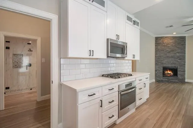a kitchen with cabinets appliances and wooden floor