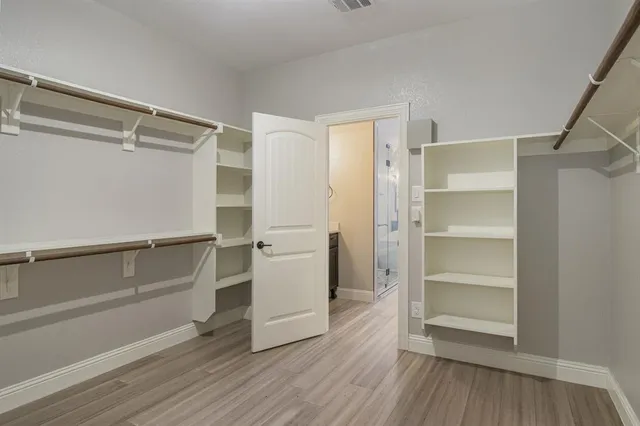 a view of walk in closet with empty racks