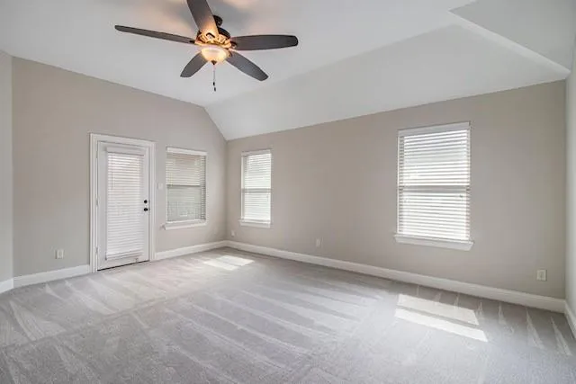 an empty room with fan and windows