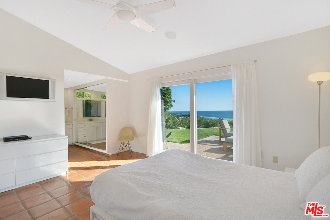 6249 Tapia Drive Malibu, CA 90265 - Photo 14 of 21 a bedroom with a bed and a large window