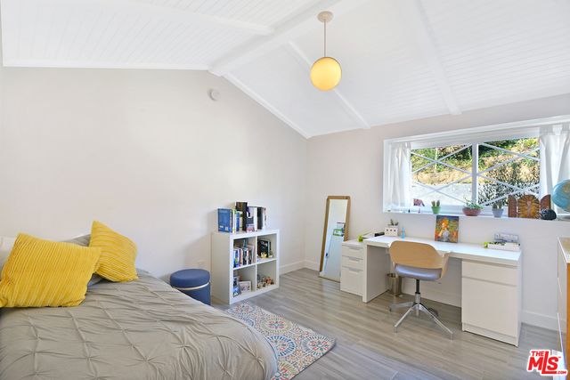 a bedroom with a bed and a wooden floor