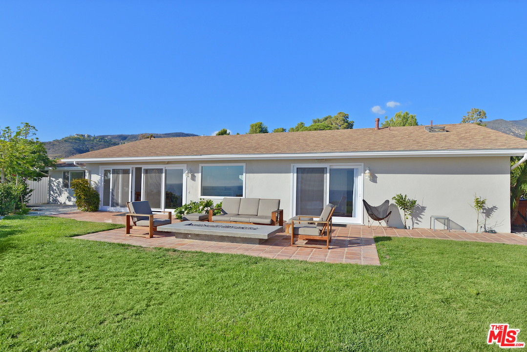 6249 Tapia Drive Malibu, CA 90265 - Photo 21 of 21 a view of a patio with table and chairs under an umbrella